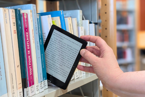 Une personne prend un livre numérique.