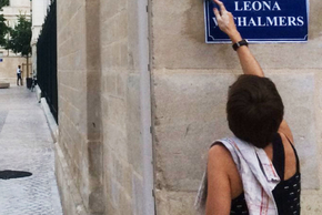 Une personne colle un nouveau panneau de rue.