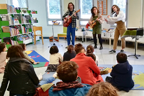 Des étudiants du CFMI jouent des instruments devant un public d'enfants et d'adultes dans la médiathèque de la Blaiserie