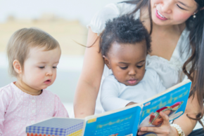 Une personne lit un livre à deux enfants.