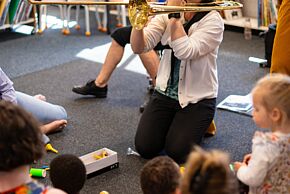 À-tout-petits sons à Médiasud : Animatrice en train de jouer d'un instrument devant un public d'enfants