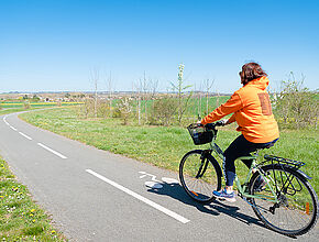 Femme faisant du vélo sur une petite route de campagne - Agrandir l'image (fenêtre modale)