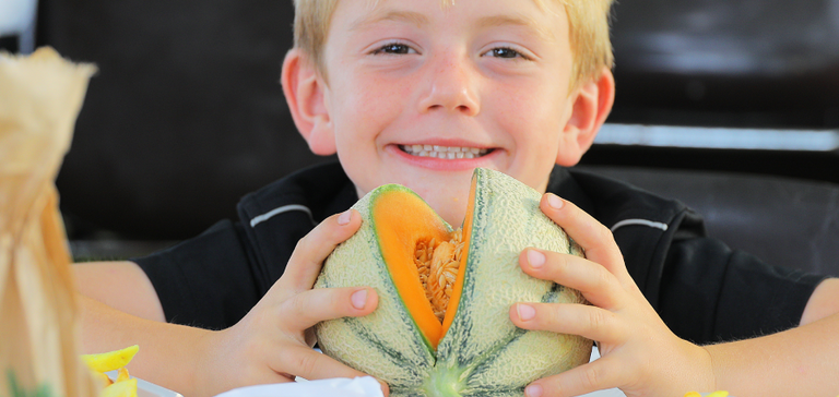 Enfant mangeant un melon