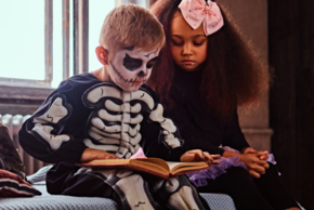 Deux enfants déguisés lisent un livre