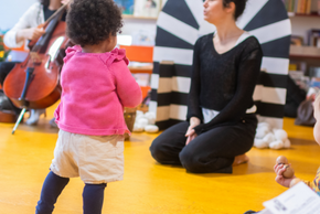 Séance d'À Tout-Petits Sons à la médiathèque des Couronneries : une petite fille regarde la danseuse et la musicienne.