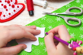 Enfant en train de dessiner un sapin sur du papier cadeau.