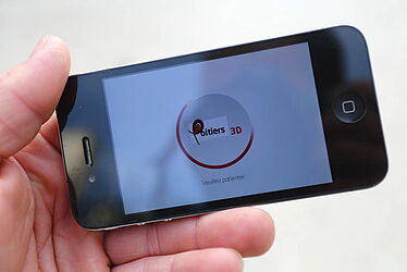 Personne utilisant l'application "Poitiers 3D" sur un téléphone