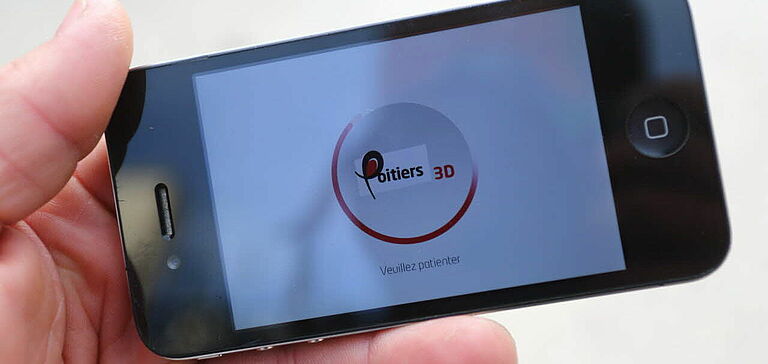 Personne utilisant l'application "Poitiers 3D" sur un téléphone
