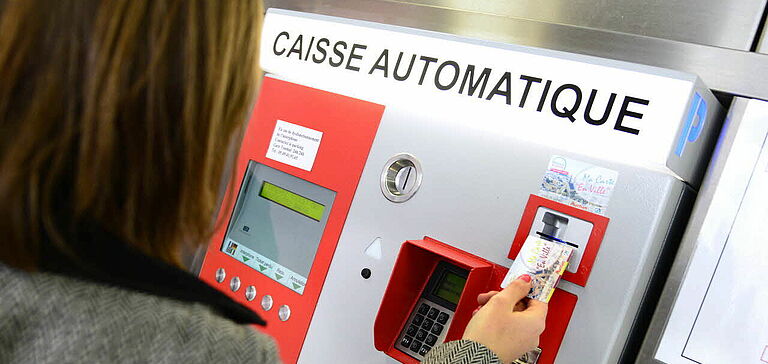 Personne payant son parking à l'aide d'une caisse automatique