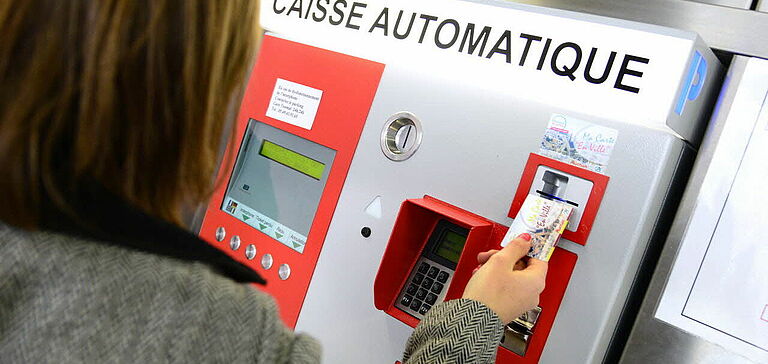 Personne payant son parking à l'aide d'une caisse automatique