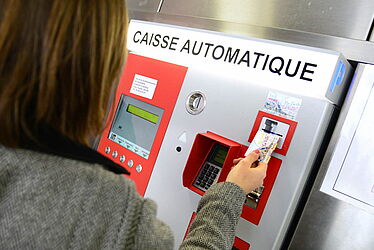 Personne payant son parking à l'aide d'une caisse automatique
