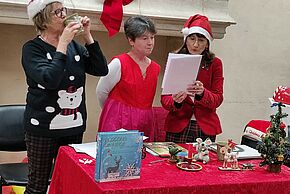 Le père noël lit une histoire à des enfants