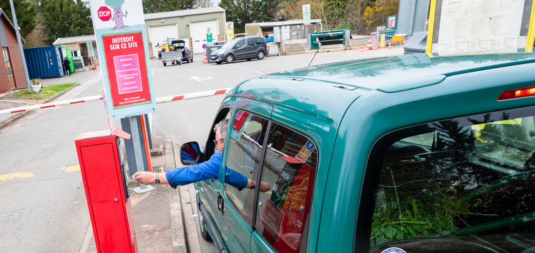 Homme en voiture au niveau d'un distributeur de tickets d'une déchetterie