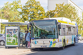 Bus à un arrêt de bus avec des personnes qui y montent