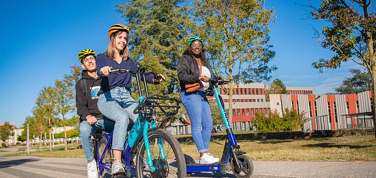 Personnes sur un vélo et une trottinette en libre-service