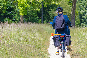 Personne circulant à vélo sur un chemin.